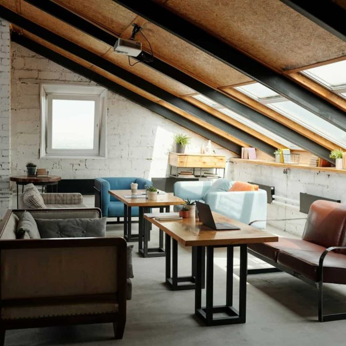 Interior of spacious loft studio or coworking space with table in the center